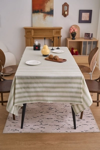 Close-up of green striped linen tablecloth texture on a wooden dining table
