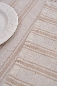 Close-up of khaki cotton linen tablecloth texture with dual-tone woven stripes and neat hem