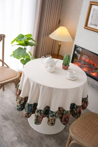 Detailed view of cream round tablecloth with vintage floral jacquard ruffled edges