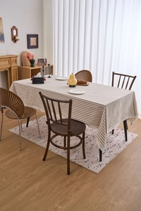 Close-up of light brown striped tablecloth with exquisite white lace trim detail