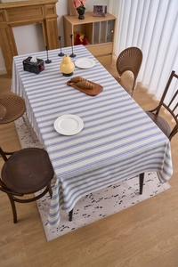 Detailed close-up of blue and white striped cotton linen tablecloth with lace edges