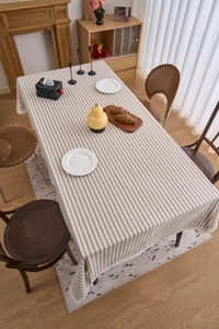 Close-up of brown striped tablecloth with vintage beige lace trim on a wooden table