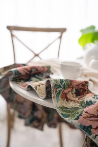 Detail of floral jacquard tablecloth featuring pink roses and retro French country texture