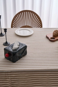 Detail of beige striped tablecloth with elegant lace trim in a cozy home dining setting