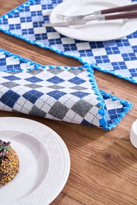 Macro detail of blue checkered placemat with exquisite light blue crochet lace edge decoration