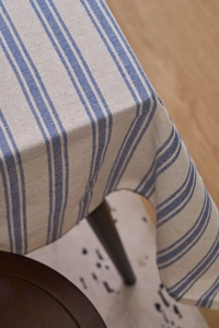 Detailed view of striped linen tablecloth showing fabric texture and elegant blue stripes