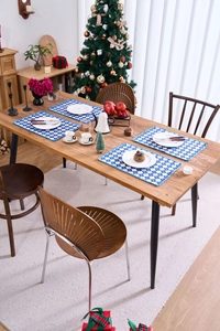 Close-up of blue and white checkered placemats in a festive Christmas dining setting