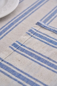 Detail of blue and white striped cotton linen tablecloth with delicate lace edging