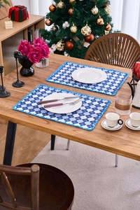 Blue and white plaid placemat with delicate lace trim on a festive wooden dinner table