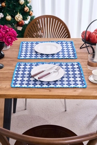 Blue and white checkered placemats with crochet lace edges on a wooden table setup
