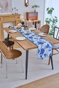 Close-up of blue and white floral table runner with intricate woven lace edge
