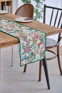 Detailed jacquard fabric texture of table runner with tropical palm leaf and butterfly motifs