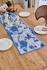 Close-up of vintage blue floral jacquard table runner with scalloped crochet lace edges