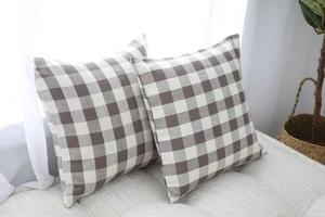 Detail of brown and beige gingham throw pillows on a fabric sofa with cotton linen texture