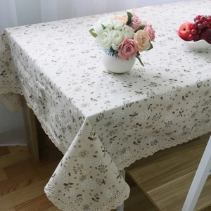 Detail of floral rectangular tablecloth with delicate lace borders in a rustic setting