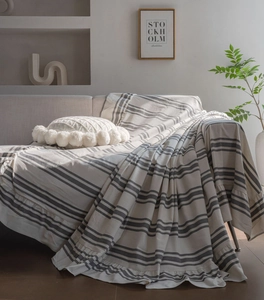 Detail of striped cotton sofa cover with ruffled edges and soft texture in cozy room