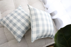 Detail of blue gingham plaid cushion cover with invisible zipper on beige sofa
