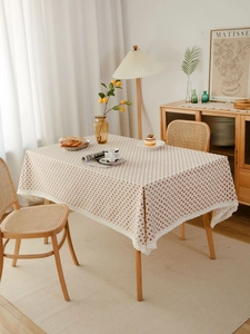 Close-up of cream rectangular tablecloth with heart patterns and white lace trim