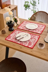 Detail of red jacquard table mat set featuring butterfly embroidery on cotton linen