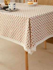 Detail of strawberry print tablecloth with delicate white lace trim on cotton linen fabric