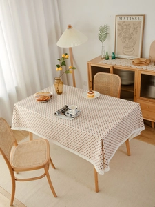 Detail of strawberry pastoral table cloth featuring brown leaf prints and delicate lace edge