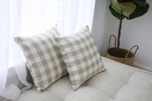 Close-up of beige and white plaid geometric cushion covers on a modern sofa set