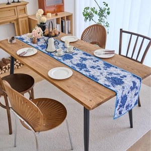 Elegant navy blue floral table runner with intricate white background on a wooden table