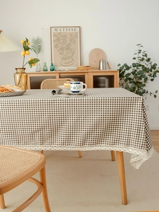 Close-up of brown plaid tablecloth with delicate white lace edge and cotton linen texture