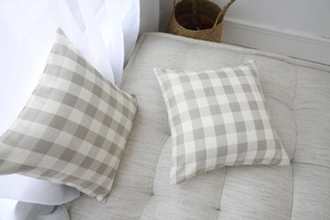 Detailed texture of khaki and cream plaid cotton linen cushion covers on a sofa