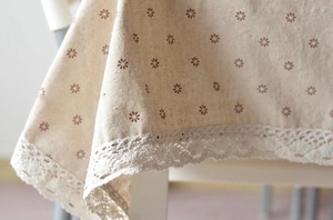 Close-up of linen tablecloth with floral print and handmade crochet lace border edge