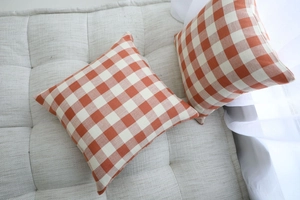 Close-up of orange gingham pattern cushion covers showing the thick linen fabric texture