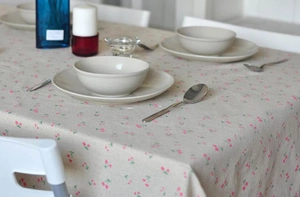 Close-up of linen tablecloth with pink floral pattern and soft woven texture