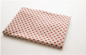 Close-up of strawberry pattern linen tablecloth fabric with folded textile texture