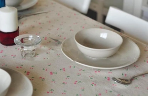 Close-up of beige linen tablecloth featuring pink cherry floral pattern in a home setting