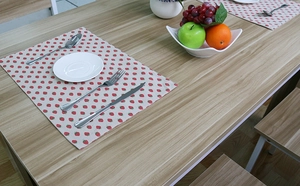 Detailed view of rectangular cotton linen placemat with strawberry print on wood table