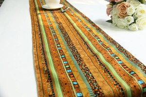 Detail of bohemian cotton linen table runner with geometric patterns and floral decor