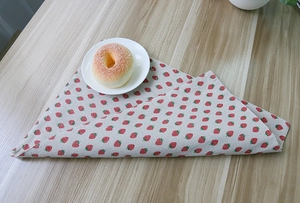 Close-up of strawberry print cotton linen tablecloth showing thick texture and folded edge