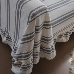 Minimalist grey striped cotton sofa cover with elegant ruffled edges for modern home decor