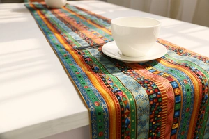 Detail of colorful ethnic pattern table runner with cotton linen texture on white table