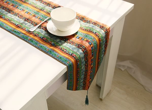 Close-up of bohemian table runner with geometric prints and cyan decorative tassels