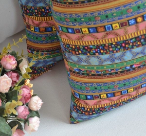 Detailed view of bohemian geometric pattern pillow covers on a soft fabric sofa