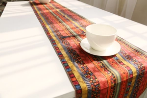Detail shot of bohemian striped cotton linen table runner on a white dining table