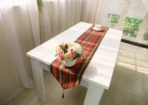 Detail of bohemian woven table runner with colorful stripes and ethnic fringe tassels