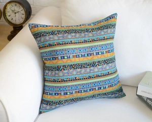 Bohemian style colorful striped pillow case displayed on a white fabric sofa in home setting
