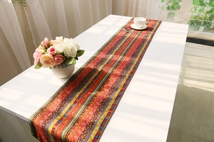 Detailed view of bohemian cotton linen table runner with ethnic patterns on white table