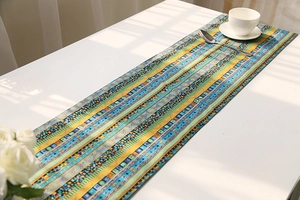 Detail of bohemian cotton linen table runner with ethnic geometric patterns in blue and gold