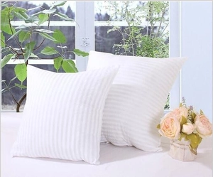 Close-up of white decorative square pillowcases with subtle vertical striped texture