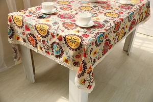 Detail of bohemian linen tablecloth with colorful mandala pattern and lace edges
