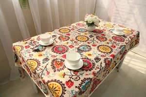 Detail of bohemian mandala linen tablecloth with delicate white lace border and floral pattern
