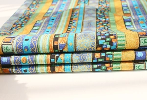 Detail of ethnic geometric pattern fabric with gold and teal bohemian textures
